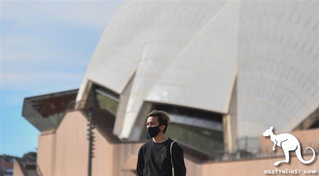 8月4日,一名行经<a href='/city/Sydney/' target='_blank'>悉尼</a>歌剧院附近的男子戴上口罩。(SBS图片)